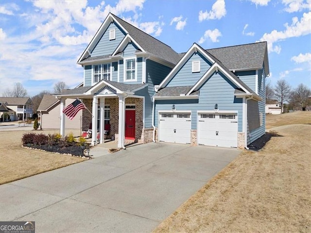 view of front of home featuring a garage, driveway, a front lawn, and roof with shingles