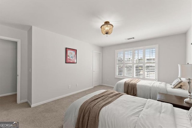 bedroom with light carpet, visible vents, and baseboards