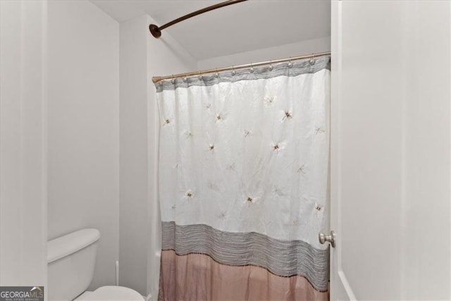 full bathroom with toilet and curtained shower