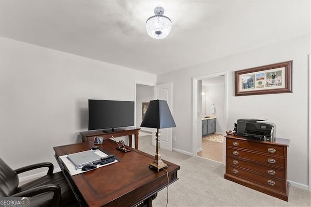 home office with baseboards and light colored carpet