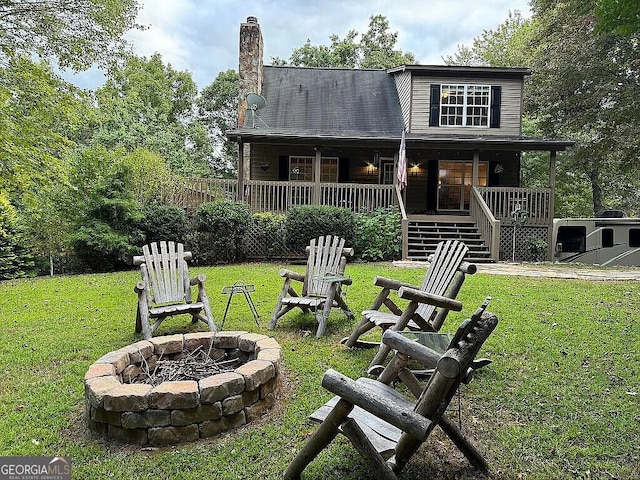 exterior space with a fire pit, stairway, a lawn, and a chimney