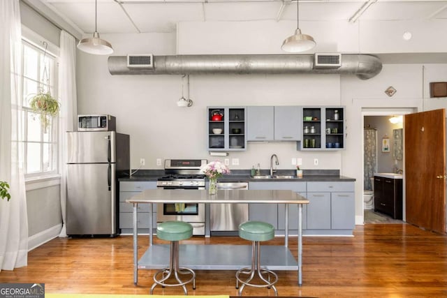 kitchen featuring open shelves, visible vents, stainless steel appliances, and a sink