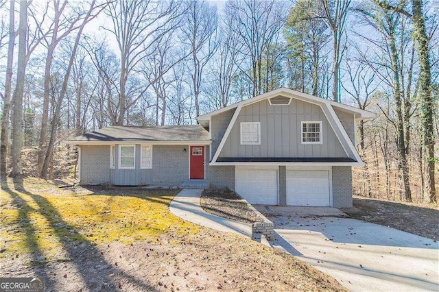 split level home with brick siding, board and batten siding, an attached garage, and a gambrel roof