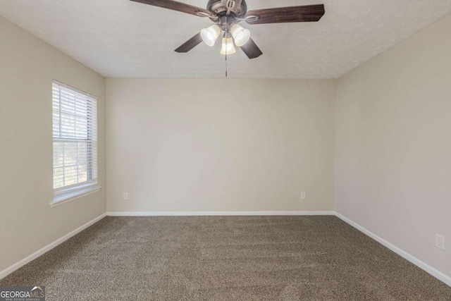 carpeted empty room featuring ceiling fan, a textured ceiling, and baseboards