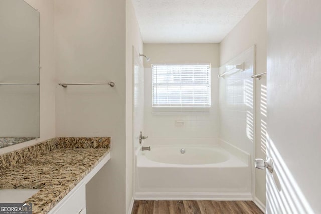 bathroom with vanity, bathing tub / shower combination, a textured ceiling, and wood finished floors