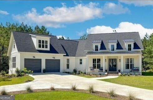 view of front facade with an attached garage, a porch, a front lawn, and concrete driveway