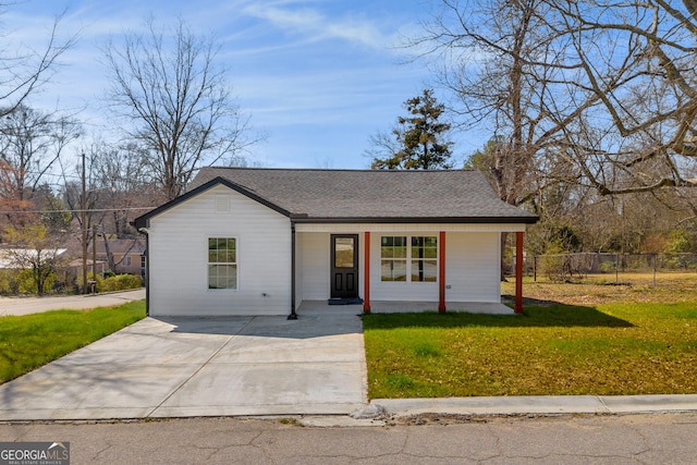 view of front of property with a front lawn, roof with shingles, a porch, and fence