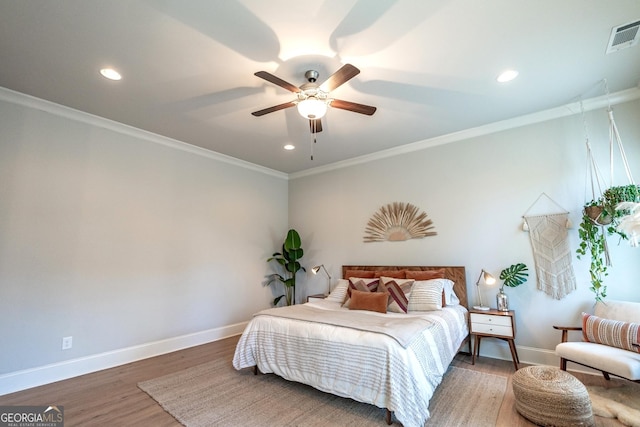 bedroom with crown molding, wood finished floors, and baseboards