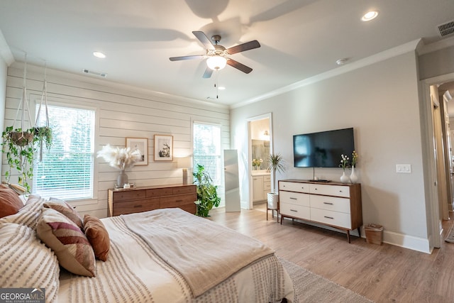 bedroom with light wood-style floors, visible vents, ornamental molding, and baseboards