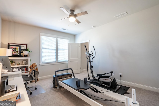 exercise area featuring baseboards, visible vents, ceiling fan, and light colored carpet