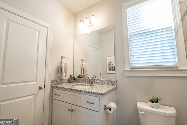 bathroom featuring toilet, a healthy amount of sunlight, and vanity