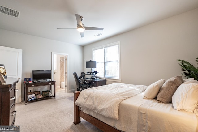 bedroom with a ceiling fan, connected bathroom, visible vents, and light colored carpet