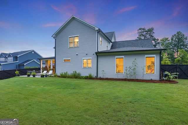 back of house featuring a yard and fence