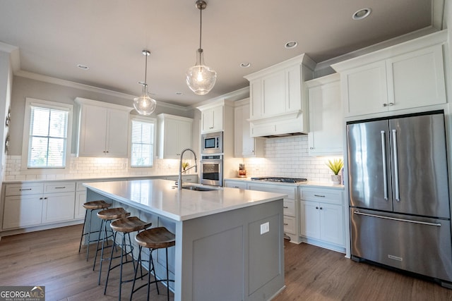 kitchen with an island with sink, white cabinetry, stainless steel appliances, and dark wood finished floors