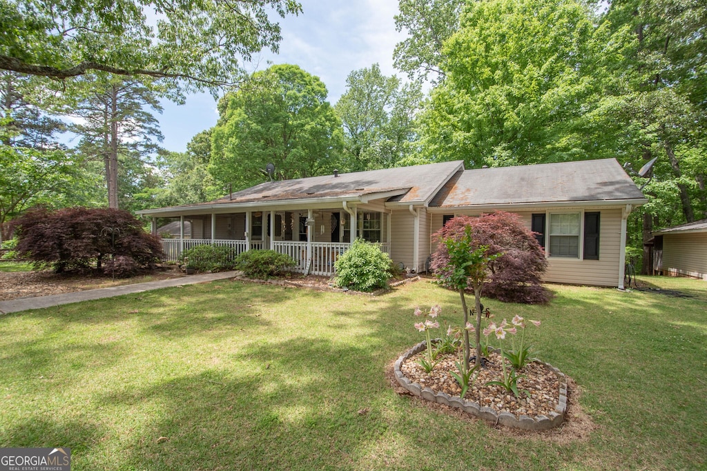 single story home featuring covered porch and a front lawn