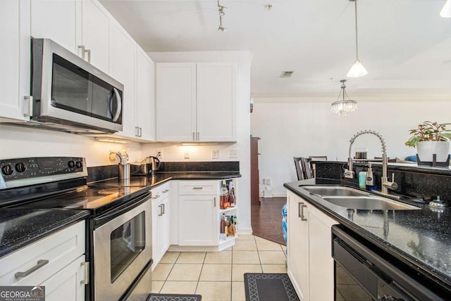 kitchen featuring light tile patterned floors, white cabinetry, stainless steel appliances, and a sink