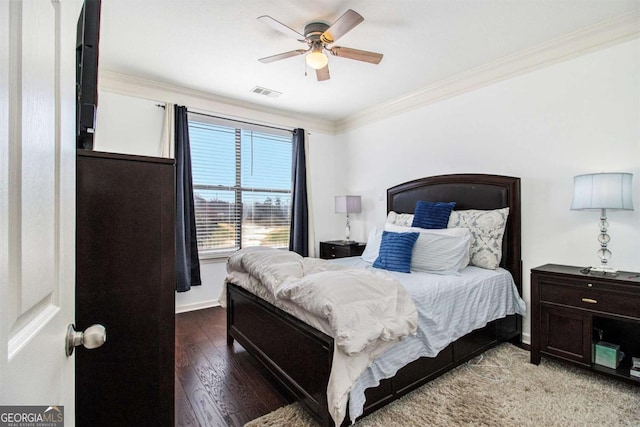 bedroom with ceiling fan, wood finished floors, visible vents, baseboards, and ornamental molding