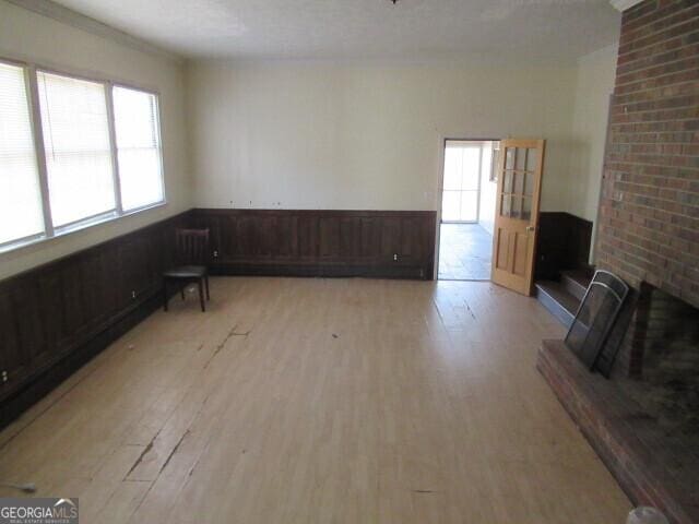 living room featuring a wainscoted wall, light wood-type flooring, and wooden walls