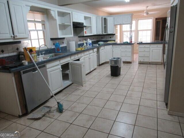 kitchen with light tile patterned floors, plenty of natural light, stainless steel appliances, and a sink