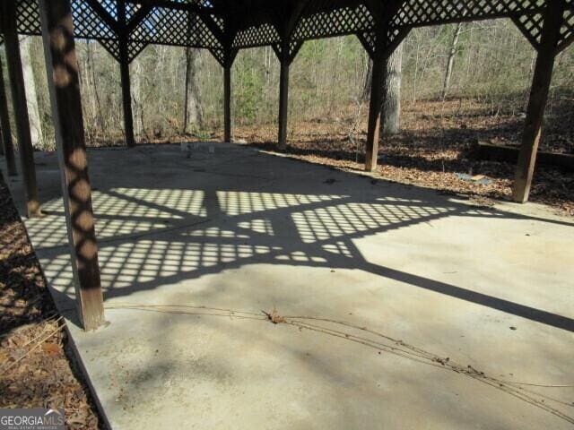 view of patio / terrace with concrete driveway and fence