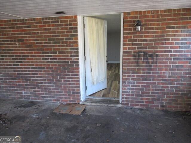 doorway to property with brick siding