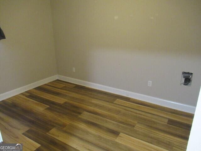 spare room featuring wood finished floors and baseboards