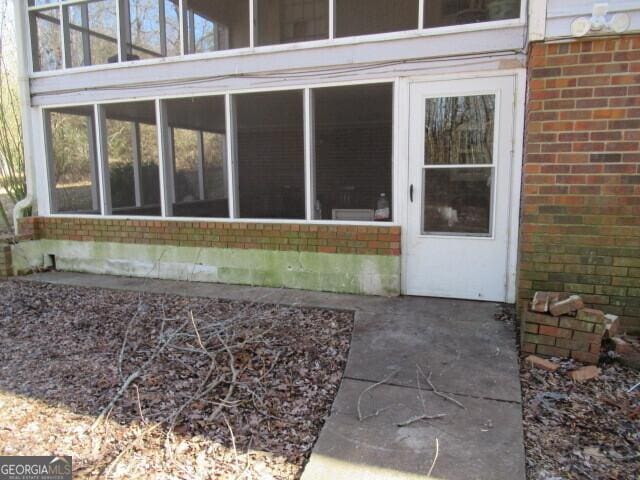 doorway to property featuring brick siding