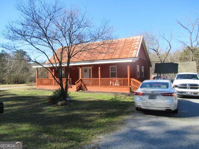 view of front facade with driveway, a porch, and a front lawn