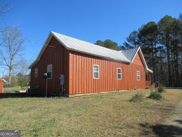 view of side of property with metal roof, a yard, and board and batten siding