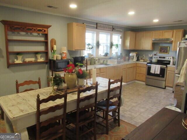 kitchen with crown molding, light countertops, appliances with stainless steel finishes, light brown cabinets, and under cabinet range hood