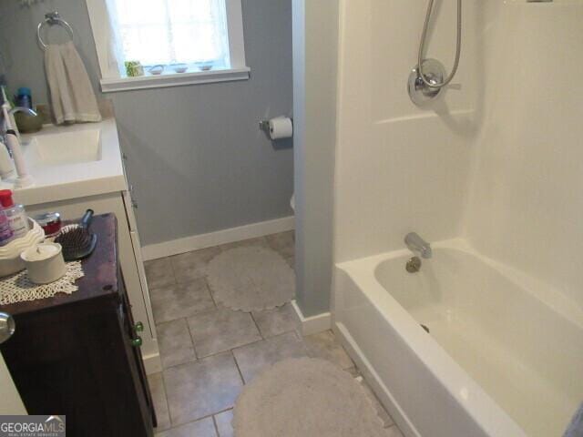 bathroom featuring baseboards, shower / bathing tub combination, vanity, and tile patterned floors