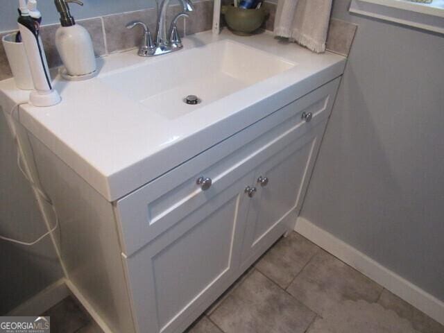 bathroom featuring vanity, baseboards, and tile patterned floors