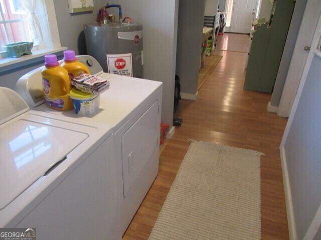 clothes washing area with laundry area, light wood finished floors, independent washer and dryer, and electric water heater