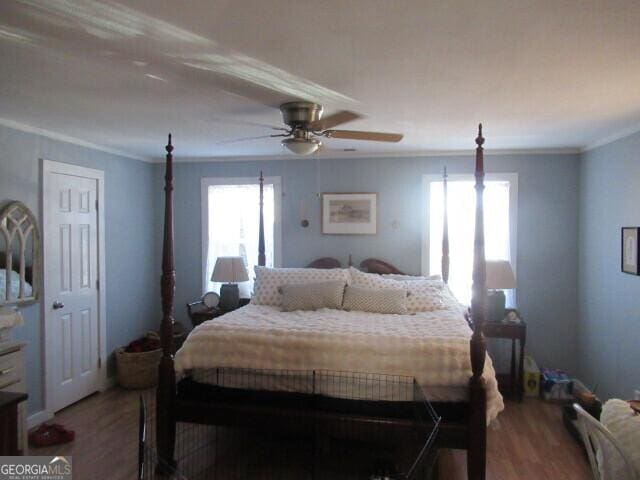 bedroom featuring ornamental molding, wood finished floors, and a ceiling fan