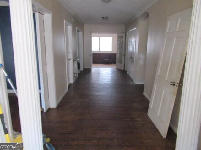 corridor with baseboards and wood finished floors