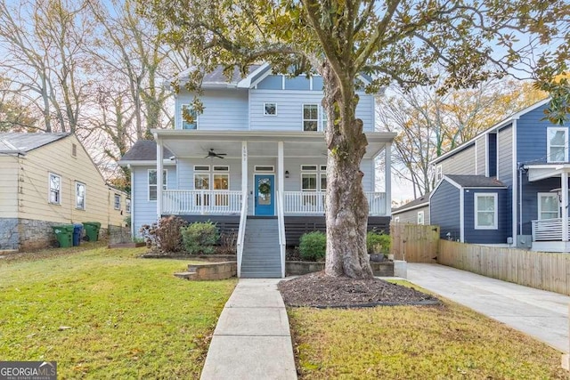 view of front facade with a porch, stairway, a ceiling fan, fence, and a front lawn