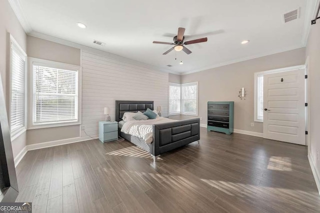 bedroom with dark wood-style flooring, visible vents, crown molding, and baseboards