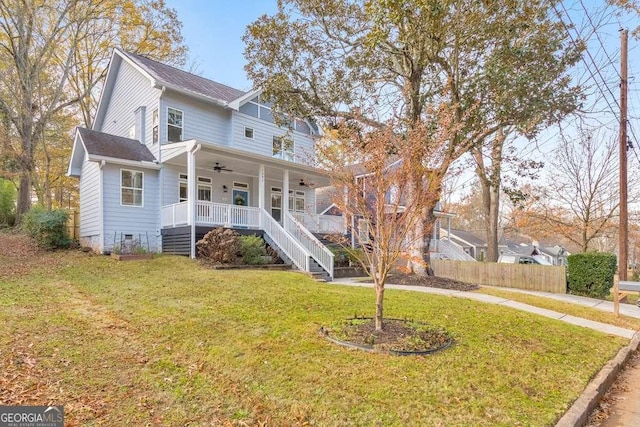 view of front of home with a porch, stairway, a front yard, ceiling fan, and fence