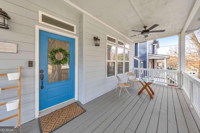 wooden terrace featuring ceiling fan and a porch