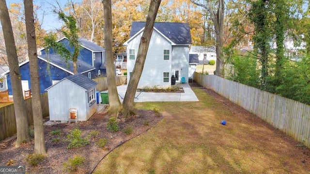 exterior space featuring an outbuilding, a shed, a patio area, and a fenced backyard