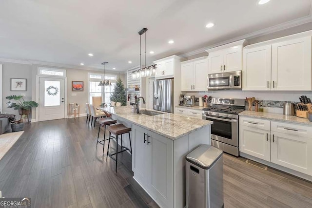 kitchen featuring dark wood-style floors, white cabinetry, stainless steel appliances, and crown molding