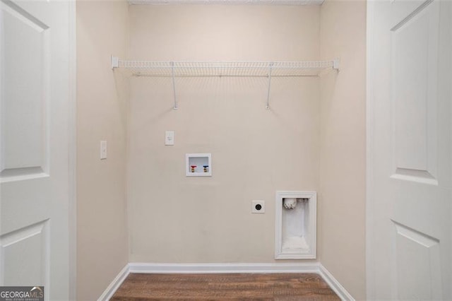 clothes washing area with dark wood-style floors, hookup for a washing machine, hookup for an electric dryer, laundry area, and baseboards