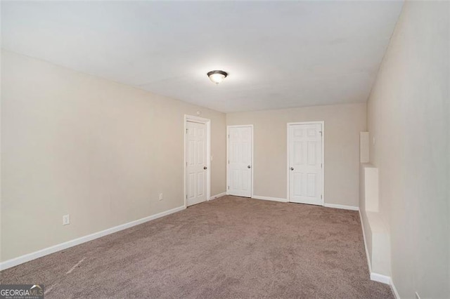 carpeted spare room featuring baseboards