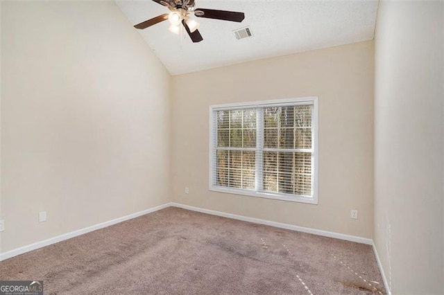 carpeted empty room featuring baseboards, visible vents, vaulted ceiling, and a ceiling fan