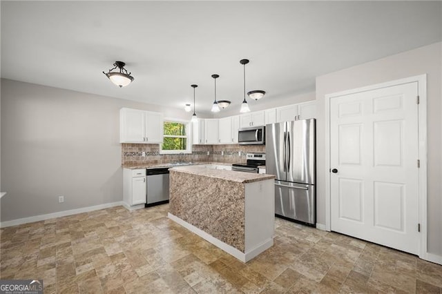 kitchen with tasteful backsplash, white cabinetry, stainless steel appliances, and baseboards