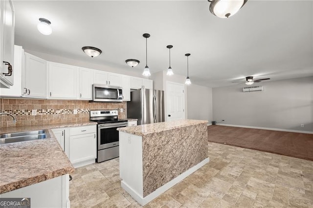 kitchen featuring a center island, stainless steel appliances, decorative backsplash, white cabinets, and a sink