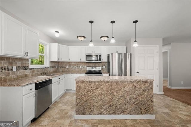 kitchen with stainless steel appliances, a sink, white cabinetry, and decorative backsplash