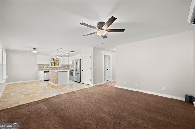 unfurnished living room with light carpet, a ceiling fan, and baseboards