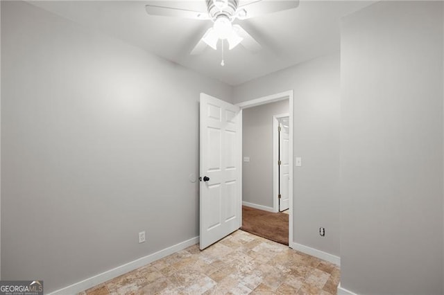 unfurnished bedroom with ceiling fan and baseboards