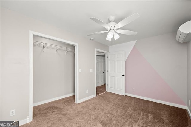 unfurnished bedroom featuring an AC wall unit, a closet, carpet flooring, and baseboards